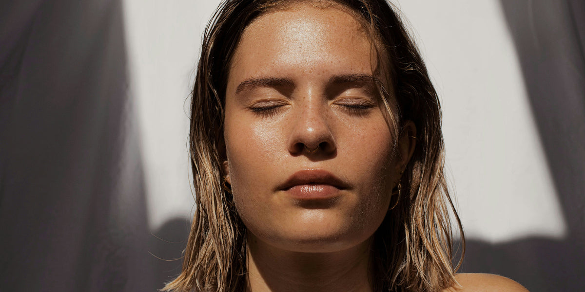 Young woman turning her face towards bright sunlight