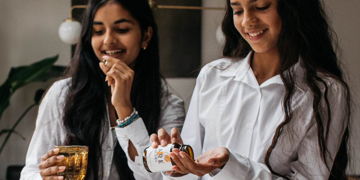 Teenage girls taking Bare Biology Life & Soul Omega-3 Mini Capsules.