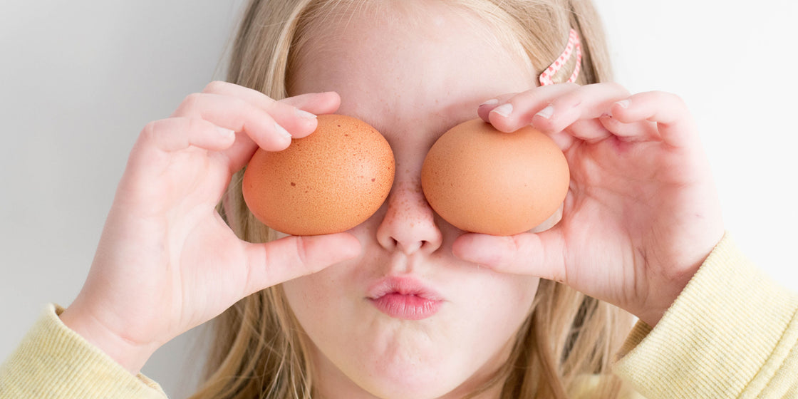 a-girl-holding-two-eggs-up-to-her-eyes