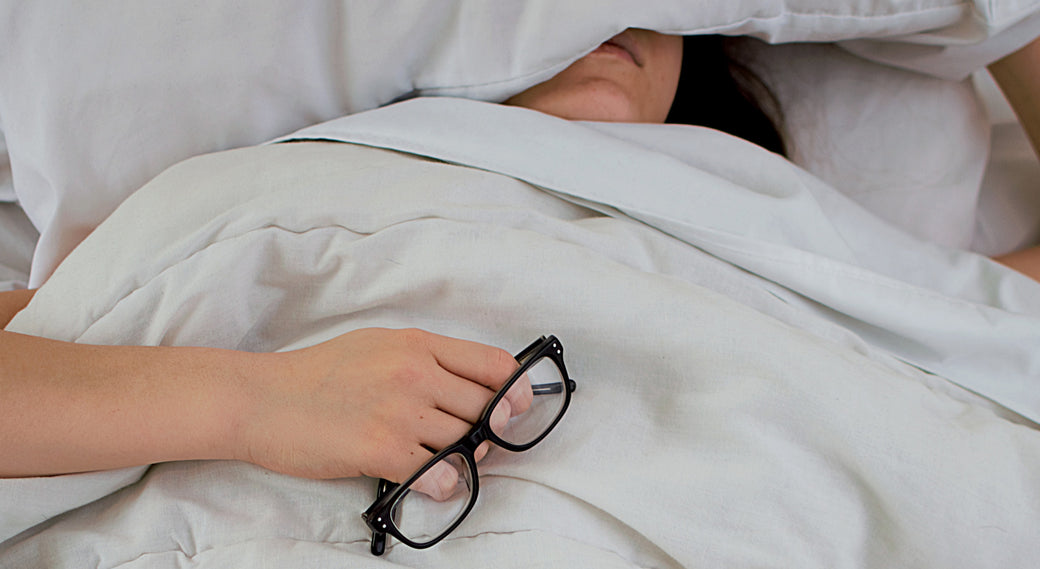 a woman in bed with glasses