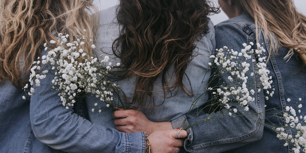 3-ladies-holding-baby's-breath-behind-their-backs