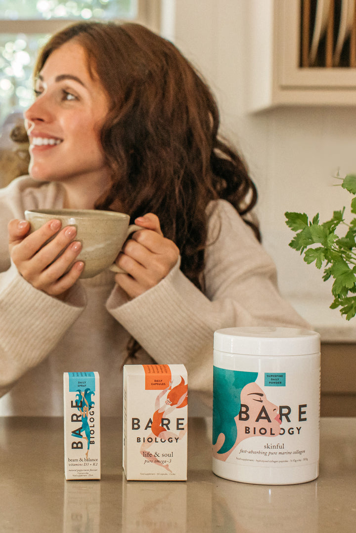 bare biology bestsellers line up on a table in front of a women holding a mug