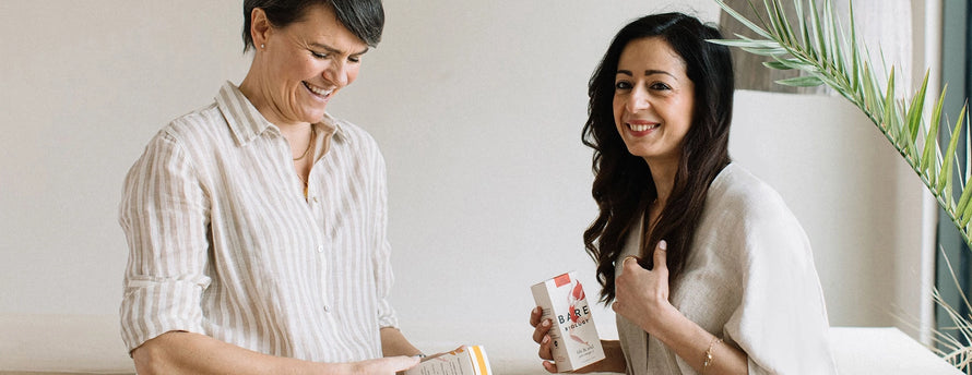 two women smiling and holding bare biology fish oil boxes