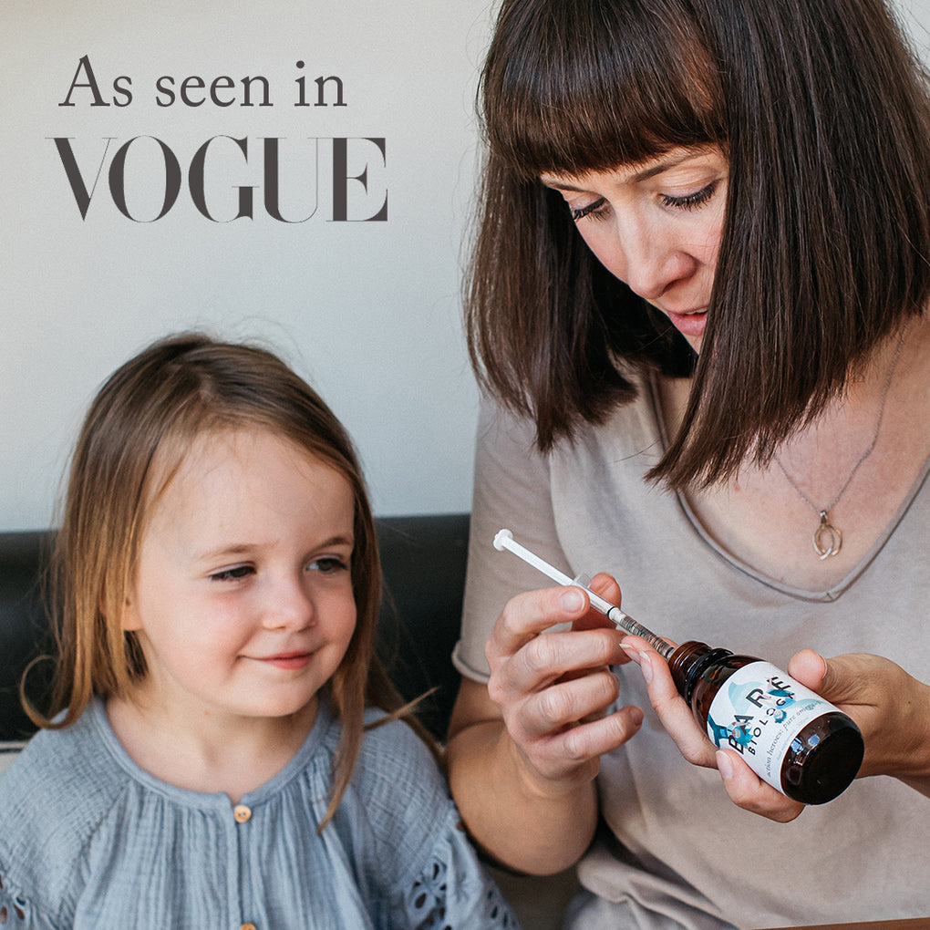 little girl sitting with her mum who is prepping a dose of bare biology kids omega-3 fish oil with syringe 