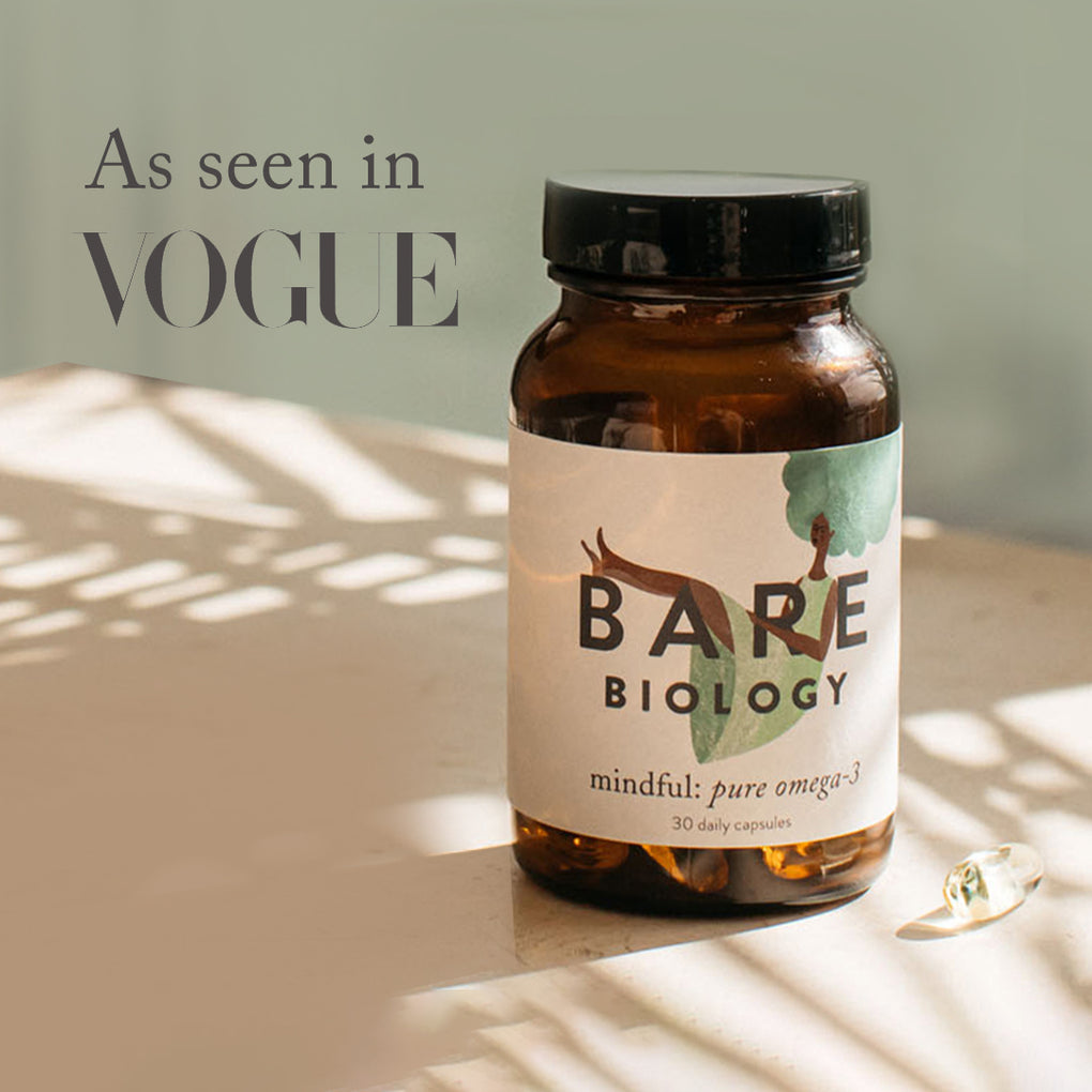 Jar of Bare Biology DHA omega-3 capsules on table with sunny plant shadows and a press feature: As seen in Vogue