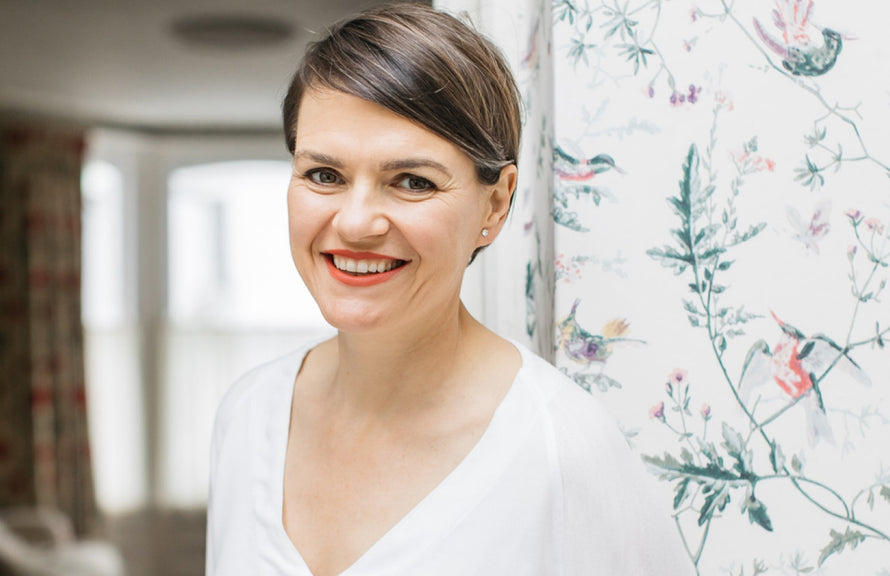 Founder of bare biology Melanie Lawson against floral wallpaper