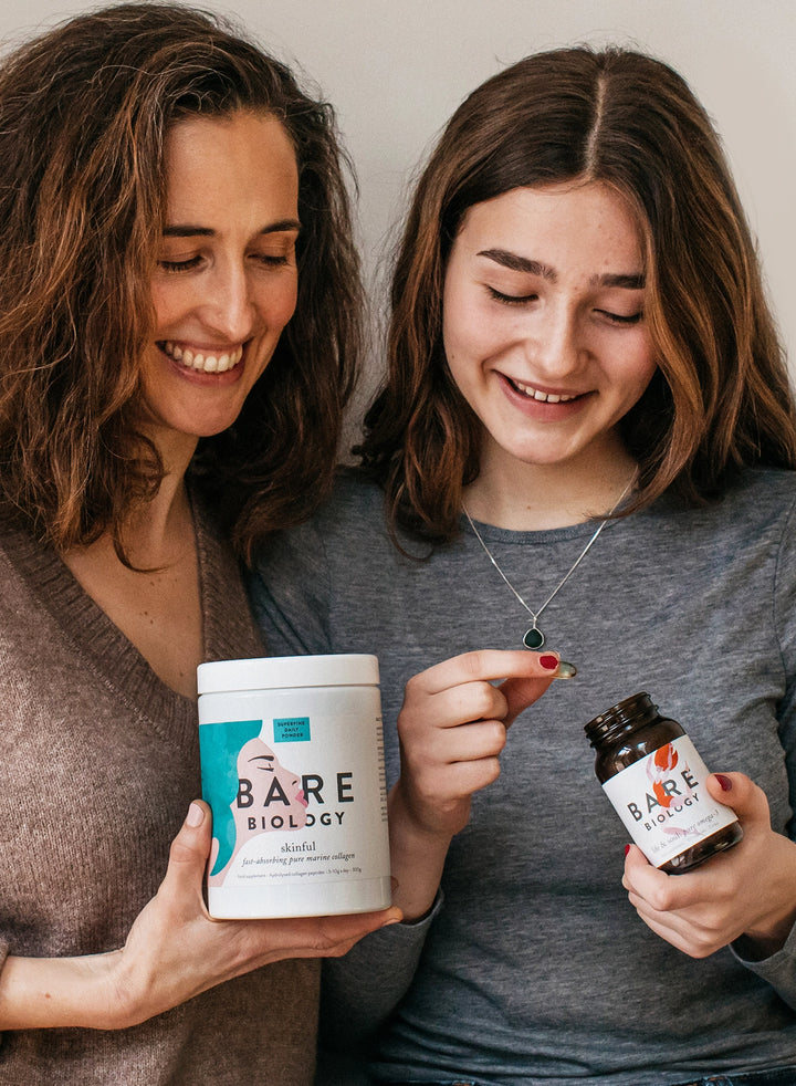 mother and daughter smiling together and holding bare biology supplements